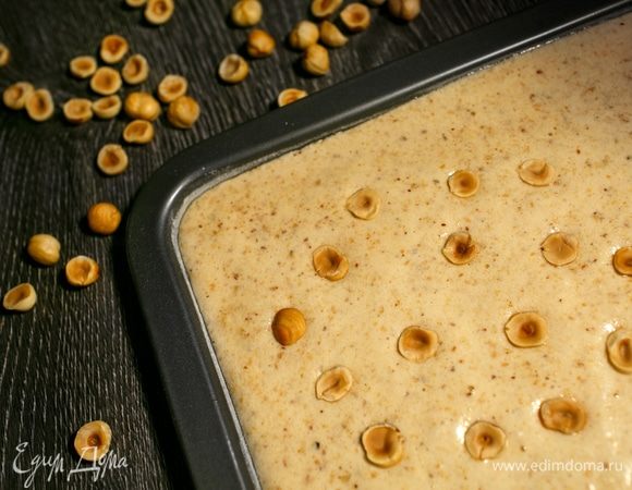 Затем я вылила тесто в противни (предварительно взвесив и разделив массу пополам, чтобы получилось 2 одинаковых коржа) и положила сверху половинки жареного фундука. Толщина теста получилась примерно 1 см.