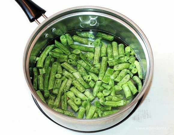 Подготовим овощи. В кипящую подсоленную воду положите стручковую фасоль. Варите 5–7 минут до готовности. Затем воду слейте, фасоль охладите. 
