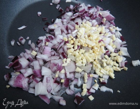 Лук и чеснок нарезать кубиками и обжарить до готовности на растительном масле в кастрюле или глубокой сковороде, где будет готовиться рис.
