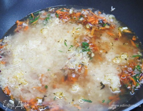 Влить соевый соус, сверху выложить промытый рис и аккуратно залить 2,5 стаканами горячей воды, не перемешивать. 