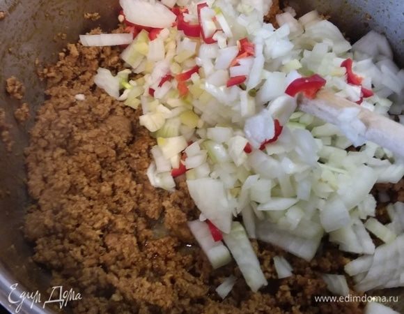 Отправить лук, чеснок, перец чили и имбирь к фаршу и обжарить вместе в течение нескольких минут. 