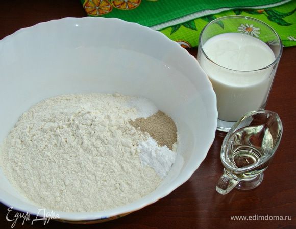 В миску просеять муку, добавить дрожжи, разрыхлитель, сахар, соль. Все перемешать. Влить растительное масло и молоко. Замесить тесто.