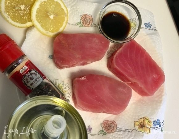 Сначала займемся тунцом. У меня были уже готовые замороженные стейки. Разморозить, помыть, обсушить бумажным полотенцем. После этого сбрызнуть каждый кусочек оливковым маслом, лимонным соком, соевым соусом, поперчить по вкусу. Солить не надо. Соевого соуса и так достаточно. Лучше подать его потом отдельно к готовой рыбе.