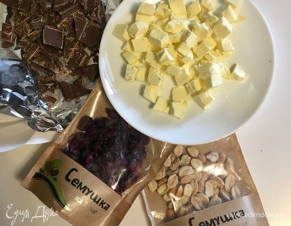 В это время приготовим начинку. В оригинальном рецепте был фундук и два вида шоколада. Я позволила себе некое отступление. Отступление оказалось очень удачным! Итак, вяленая клюква и жареный арахис. Шоколад из холодильника, поломанный на кусочки. И также обязательно холодное сливочное масло, нарезанное на кусочки. Я сначала шоколад и масло порубила, потом опять спрятала в холодильник.