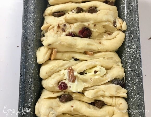 Достаем форму для выпекания из холодильника и бочками укладываем все четыре квадратика, каждый из которых состоит из 6 полосочек, плотно друг к друга разрезами вверх. В этот момент как раз и следует обратно спрятать «убежавшую начинку». Боковые квадратики должны быть начинкой внутрь.