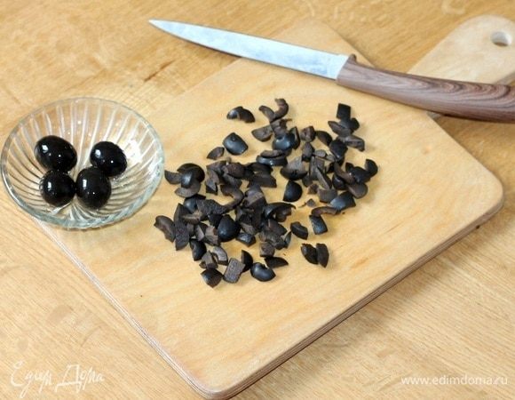 Маслины без косточек нарезать маленькими дольками.
