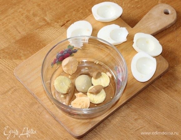 Почистить вареные яйца. Отделить белки от желтков. Желтки размять вилкой и перемешать с горчицей. Белки можно заполнить приготовленной паштетной массой. 
