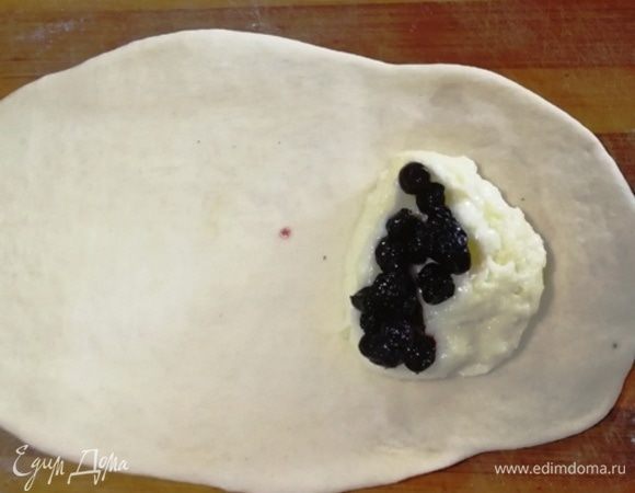 Раскатываем шарик теста в овал. На один край кладем начинку.