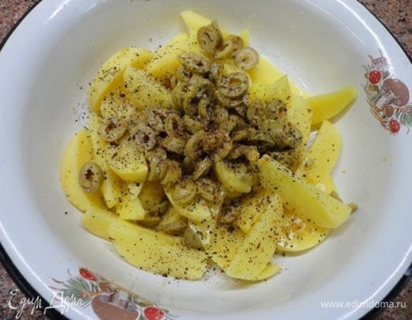 Оливки нарезать (можно предварительно размять ножом), натереть цедру с половины лимона, семена зиры (кумина) растолочь в ступке (по желанию). Все это добавить к картофелю. А также масло, свежемолотый перец и соль. Перемешать.