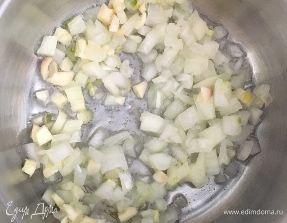 В кастрюльке разогреть оливковое масло. Сперва отправить к маслу лук и чеснок. Пассеровать до прозрачности лука.