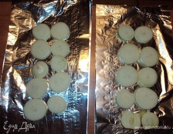 На фольгу, в несколько слоев согнутую, — лук толстенькими кольцами — нижняя «подушка».