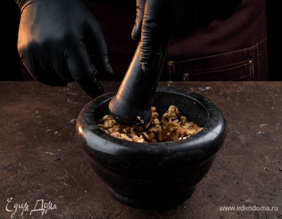 Измельчите обжаренные орехи в ступке.