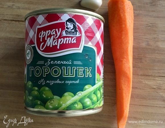 Поставить на огонь кастрюльку с водой и щепоткой соли для макарон. А тем временем подготовить овощную братию: очистить одну среднего размера морковь, один зубчик чеснока и сладкий нежный консервированный горошек ТМ «Фрау Марта».