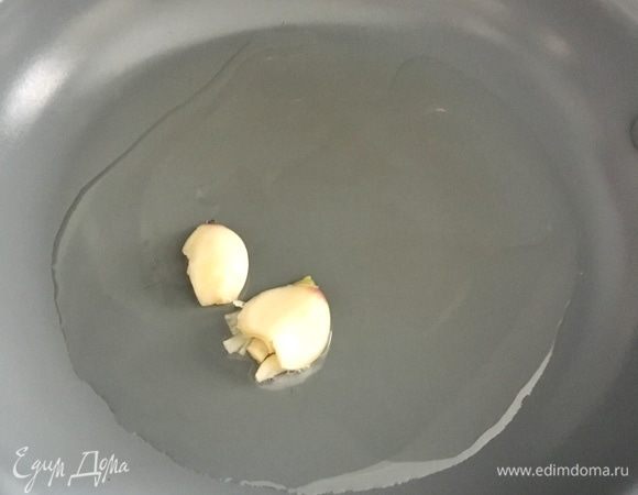 В сковороде разогреть столовую ложку оливкового масла и как только масло разогрелось, положить в него буквально на пару минут раздавленный тыльной стороной ножа зубчик чеснока. Затем чеснок извлечь. Больше он нам не понадобится, а легкие ароматы маслу он уже отдал.