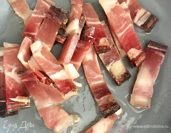 Следом положить полосочки бекона в масло и быстро обжарить со всех сторон. Снять на бумажное полотенце.