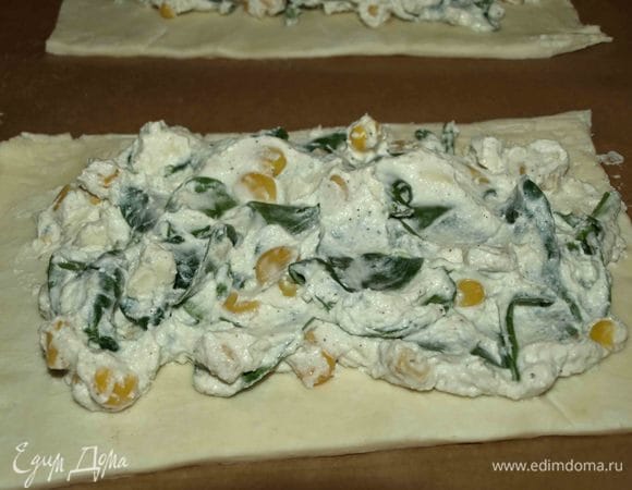 Заранее размороженное слоенное тесто раскатать. Разделить на 4 части, определить края слоек. На каждую часть выкладываем начинку. 