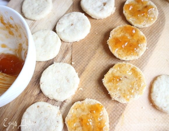 Вынуть печенье из духовки, смазать половину печенья абрикосовым джемом.