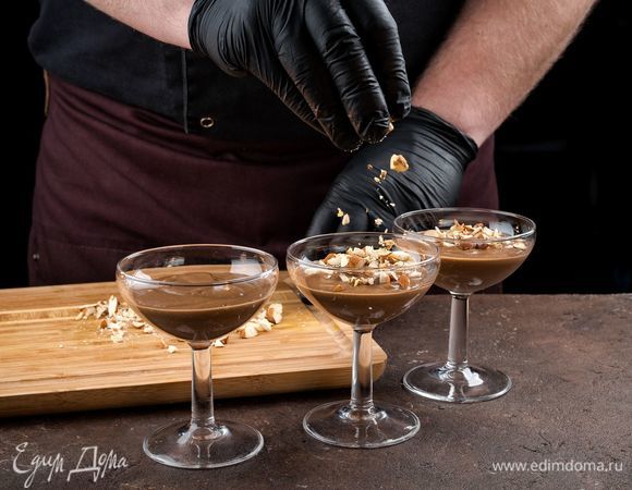 Ложкой переложите в креманки или небольшие стаканы шоколадный мусс, украсьте миндалем.