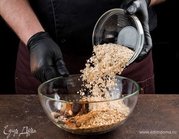 В отдельной емкости смешайте сухофрукты, орехи, овсяные хлопья. Добавьте корицу или другие пряности по вкусу.