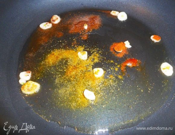 На разогретую сковороду налить растительное масло, выложить нарезанный пластинками чеснок и все пряности (можно подобрать их по своему вкусу). Обжарить на среднем огне около 2 минут.