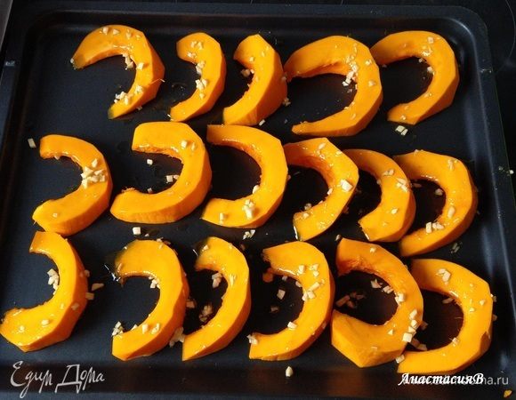 Тыкву выкладываем на противень и смазываем подготовленным оливковым маслом. После того, как будет готово тесто, запечь в духовке дольки тыквы около 25 минут на средней полке. Температуру не меняем.