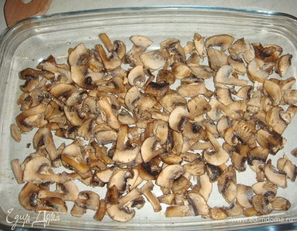 Пока курица маринуется, приготовим подложку для нее. Грибы нарезать тонкими пластинками и выложить в форму для запекания.