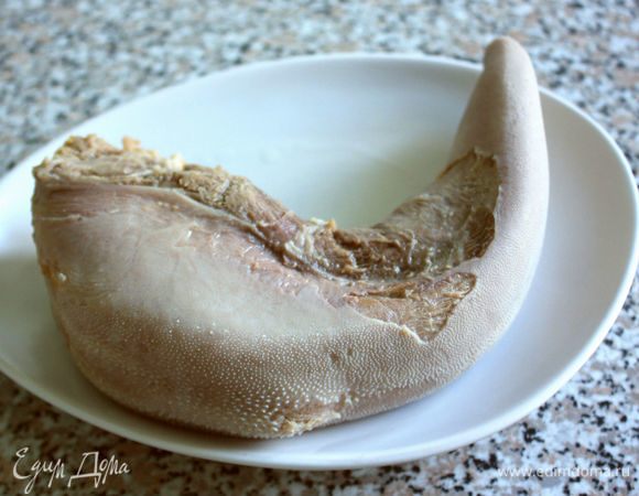 Вынуть язык из кастрюли и погрузить в холодную воду на 2 минуты, снять с него кожу. Бульон процедить, добавить в него 100 мл белого вина, готовый язык вернуть в бульон и довести до кипения, но не кипятить. Оставить остывать до того момента, когда будет готов салат или убрать на ночь в холодильник. Бульон можно использовать для приготовления лукового супа, а уж с каким потом вином, белым или красным — на ваш выбор.