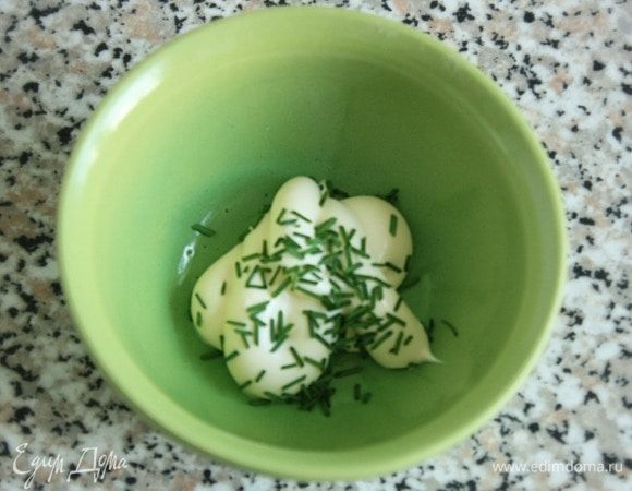 Майонез смешать с петрушкой и шнитт-луком. Майонеза здесь ничтожное количество, вреда от него не будет и заменять его сметаной не стоит — это сильно изменит вкус салата. В миске смешать хорошо отжатую кольраби (и сельдерей, если его нарезали) и яблоко, заправить майонезом, убрать салат в холодильник.