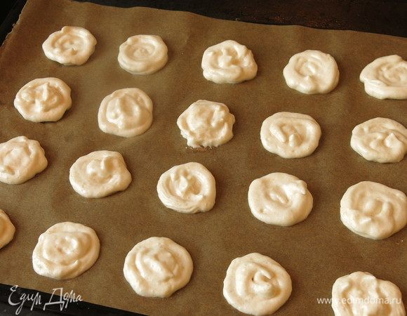 Выкладываем белок на противень, застеленный пергаментом, можно предварительно разметить кружки. Кладем на стол полотенце, бросаем противень на него пару раз — кружки разойдутся. Выдерживаем пару часов при комнатной температуре, подсушиваем белок. Всего получается больше трех десятков безе.