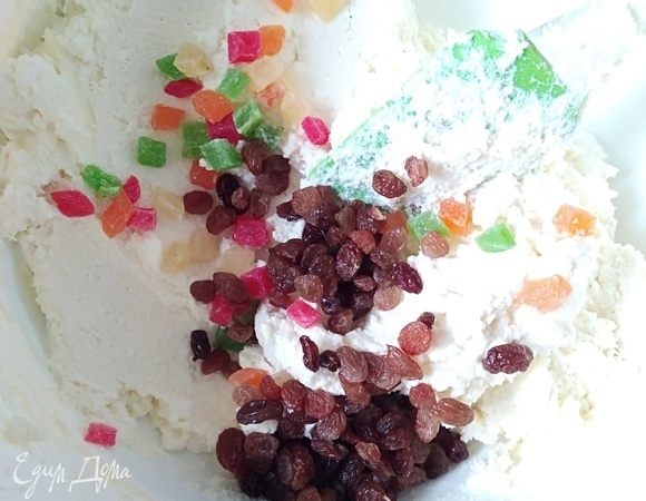 Изюм и цукаты хорошо промыть, воду слить и обсушить салфетками. По желанию можно добавить измельченные орехи. Смешать сухофрукты с творожной массой.