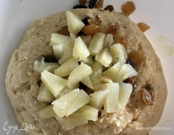 В тесто добавить орехи, изюм и ананасы. Тщательно вмешать их в тесто.