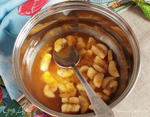 Переложить готовые фрукты, кроме банановой кожуры, в кастрюльку или сотейник. Добавить сахарный песок (3 ст. л.), молотую корицу (1/3 ч. л.) и коньяк (50 мл). Довести до кипения.