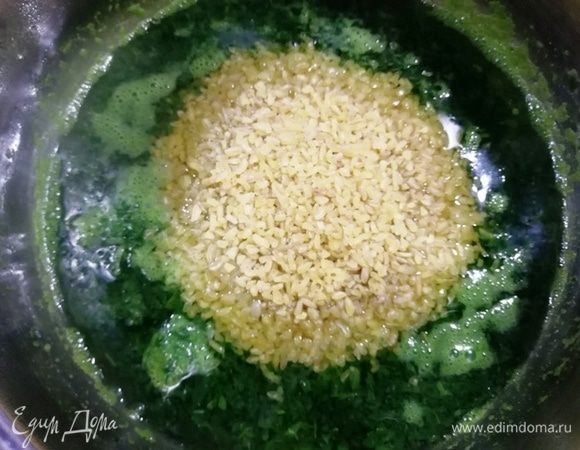 В шпинатную воду высыпать булгур и перемешать. Варим на среднем огне 15 минут. Вся жидкость за это время впитается.