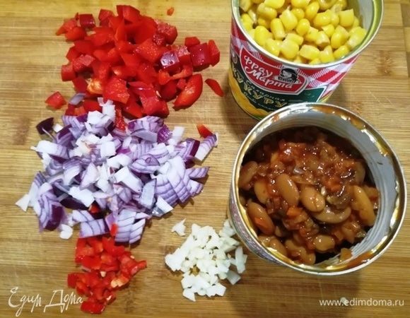 Кукурузу и фасоль «Фрау Марта» освобождаем от жидкости (она нужна для соуса). Перец, лук и чеснок нарезаем кубиком.