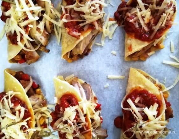 Перекладываем тако на противень, поливаем соусом, посыпаем сыром  и ставим в разогретую до 200°С духовку на 10 минут.