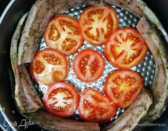 В форму для выпечки кольцом выложим рыбу, в центре уложим кольца помидора (так булгур останется сочным).