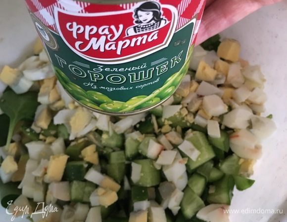 В глубокую миску положить салат айсберг, одну горсть шпината, нарезанные огурчики и яйца. Теперь очередь зеленого горошка! У нас горошек очень любят, тем более горошек ТМ «Фрау Марта» уже зарекомендовал себя с хорошей стороны. Поэтому в салатик пошла целая баночка. Разве для украшения можно оставить пару столовых ложек.