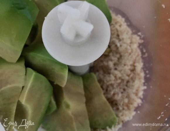 Авокадо нарезать кубиком. Половину отправить в миску к салату, а половину в блендер к измельченным орешкам. Пробить до однородной маслянистой массы.