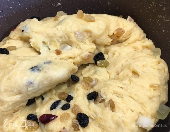После вторичного подъема теста осадить его до первоначального положения, добавить изюм, цукаты и дать тесту подойти в третий раз. Разогреть духовку до 180°C. 