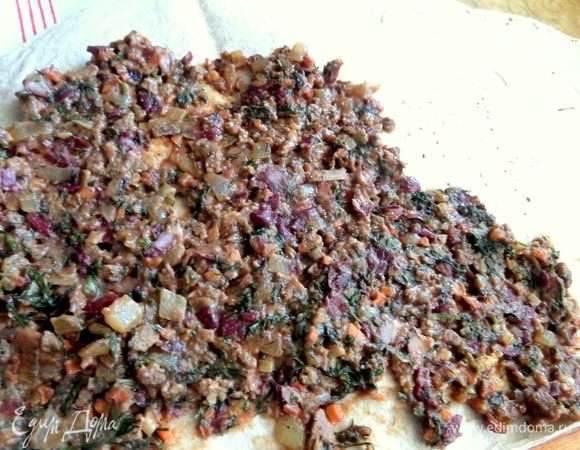 Перетереть начинку и нанести на тонкий лаваш. У меня большой пласт, отрезала лишний край. Если лаваш сухой, смочить поверхность кисточкой с водой.