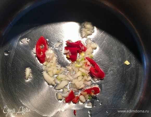 Разогреваем в кастрюльке ложку оливкового масла и отправляем в него измельченный зубчик чеснока и перец чили.