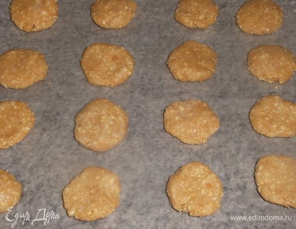 Противень застелить пекарской бумагой. Из теста сделать небольшие шарики размером с перепелиное яйцо. Сплющить его ладонями в небольшой пятачок.