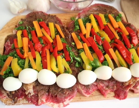 Положить вдоль куска брусочки перца и моркови.