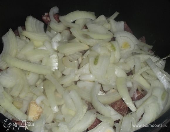 Нарезать лук. Выложить поверх мяса.