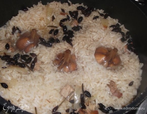 Достать. Воткнуть головки чеснока. Вода уже упарится до уровня риса. Если нужно, то еще посолить.