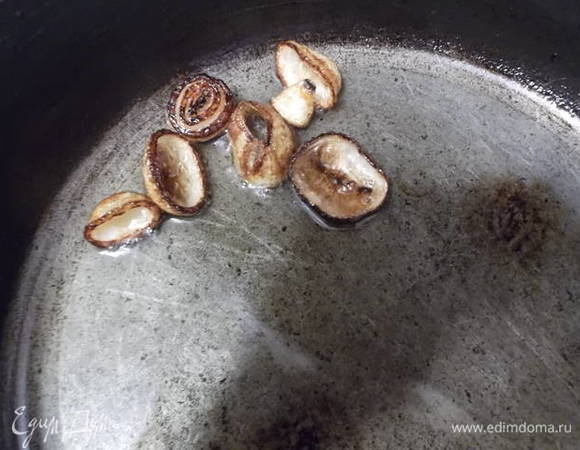 Делаем из луковицы флитюр. Луковицу нужно кидать целиком. Так более ароматное масло у вас получится. Я разрезала пополам, т.к. сковорода плоская.
