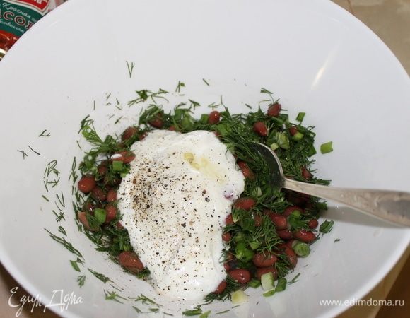 К фасоли с зеленью добавьте простоквашу и растительное масло.