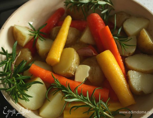 Нагреть просторную сковороду на среднем огне, влить половину рапсового или оливкового масла. Положить туда же картофель, морковь и чеснок. Посолить и несколько раз хорошо встряхнуть, чтобы масло покрыло все ингредиенты. Добавить половину сливочного масла и розмарин.
