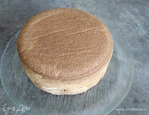 Бисквит готов, но мы не сразу достаем его из печи, а даем равномерно остынуть. Через час достаем форму, переносим бисквит на тарелку и удаляем бумагу. Даем остыть полностью. После нарезаем на три коржа и убираем в холодильник минимум на ночь.