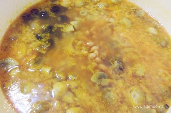 Выложить фасоль и маслины в суп, довести до кипения и томить на очень медленном огне около 10 минут.